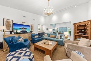 a living room with blue furniture and a chandelier at 2565 The Haul Over in Seabrook Island