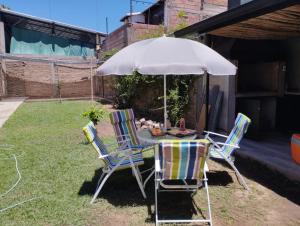 una mesa y sillas bajo una sombrilla en un patio en Casa Milo, en Mendoza
