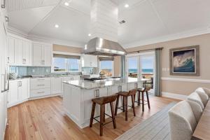 una cucina con armadi bianchi e un'isola con sgabelli da bar di DE03- Anchors Away a Nags Head