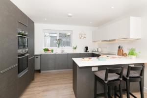 a kitchen with a large island with bar stools at Sandy Cove in Penzance