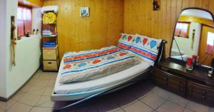 a bedroom with a bed with a dresser and a mirror at kleines Doppelzimmer mit Dusche WC in Muotathal