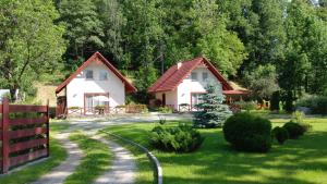 a house with a fence next to a yard at Domki Pod Jesionami in Stronie Śląskie