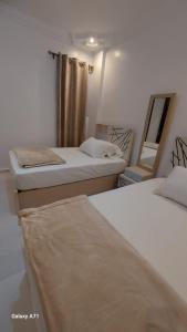 a room with two beds and a mirror at Eamar tower 2 in Tanta