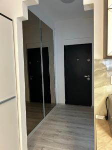 ブカレストにあるThe Lipscani Chich Studioの黒い扉2つと鏡付きの廊下