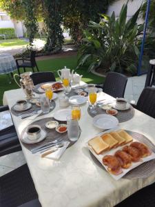 a white table with breakfast foods on it at La Maison in San Fernando del Valle de Catamarca