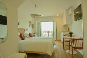 a bedroom with a bed and a table and a window at Arco da Vella apartamentos in Villanueva de Arosa