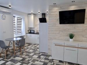 a kitchen with a table and a tv on a wall at Apart Gagarina 16 in Kropyvnytskyi