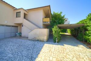 a house with a patio with an umbrella at Apartmani Kirinčić in Krk