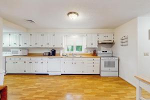 a kitchen with white cabinets and white appliances at Birch Circle Beach House in Ogunquit