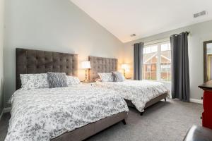 een slaapkamer met twee bedden en een raam bij Dublin Village Townhome in South Bend