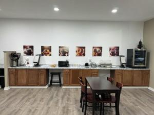 a kitchen with a counter and a table with chairs at Heritage Hotel of Quincy in Quincy
