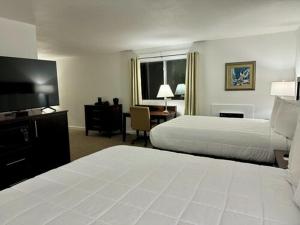 a hotel room with two beds and a flat screen tv at Heritage Hotel of Quincy in Quincy +20 photos