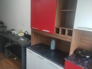 a kitchen with a red cabinet and a sink at Apartamento tipo Studio a 5 Minutos de carro do Centro in Caruaru