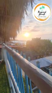a group of surfboards on a fence with the sunset at Tropical Beach in Playa Blanca