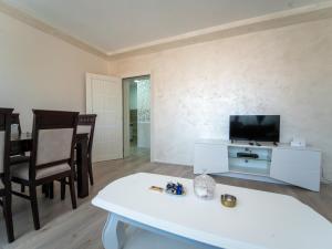 a living room with a tv and a table and chairs at Queen in Užice