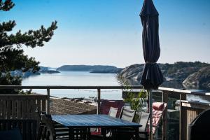 an umbrella and a table on a deck with a view of the water at Saltviks Stugby & Camping in Grebbestad