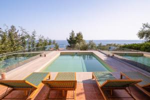 a swimming pool with a view of the ocean at Halkidiki Boho Heated Pool Beach House in Gerakini