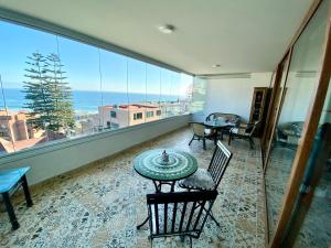 a room with a table and chairs and a large window at Reñaca, hermosa vista al mar in Viña del Mar