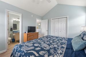 a bedroom with a bed with a blue and white bedspread at Dream23 in Corolla