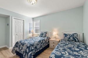 a bedroom with two beds with blue and white sheets at Dream23 in Corolla +29 photos
