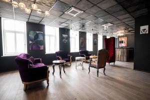 a room with purple chairs and tables and windows at Hedgehogs backpackers hostel in Riga