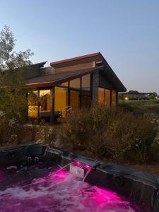 a hot tub in front of a house with pink lights at Cabañas by 7 Valles in Valle de Guadalupe