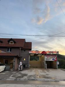 a gas station with a car parked in front of it at Apartmani Krivokuća in Sveštica