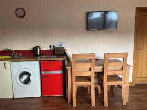 a kitchen with a table and a washing machine at Riverside Retreat in Caol