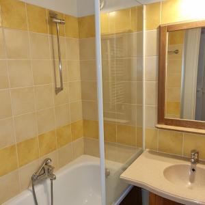 a bathroom with a tub and a sink and a mirror at Appartement Vue sur Lac in Monflanquin