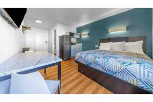 a bedroom with a bed and a blue wall at Studio 6 Seattle, WA Sea Tac Airport South in SeaTac +19 photos