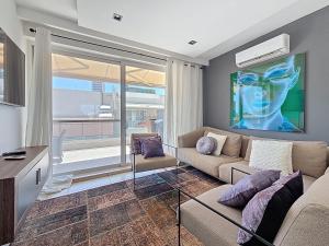 a living room with a couch and a large window at Gzira Seaview Duplex with infinity pool in Il-Gżira