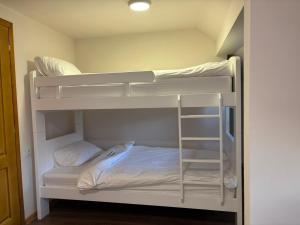 a room with two bunk beds with white sheets at Apartmani Krivokuća in Sveštica