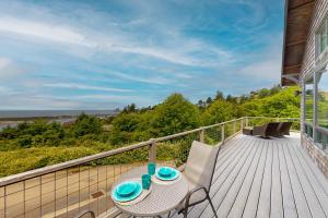 a patio with a table and chairs on a deck at Alta Vista in Pacific City