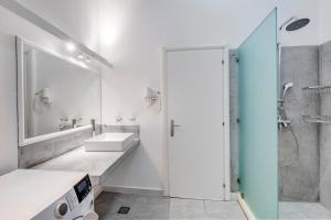 a white bathroom with a sink and a shower at Kois Loft in Ermoupoli