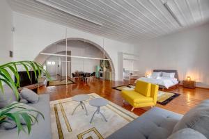 a living room with a bed and a yellow chair at Kois Loft in Ermoupoli
