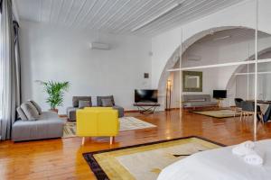 a living room with a couch and a yellow chair at Kois Loft in Ermoupoli
