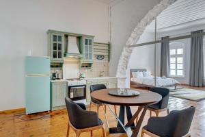 a kitchen and living room with a table and chairs at Kois Loft in Ermoupoli +26 photos
