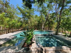 an image of a swimming pool with trees in the background at Villa with a private pool in Tulum