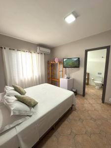 a bedroom with a large bed and a mirror at Hostel Costa Terral in Matinhos +17 photos