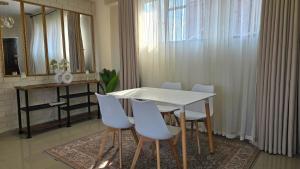 a dining room with a white table and chairs at Bright & Airy 2BR in CBD Harare Modern with city view in Harare