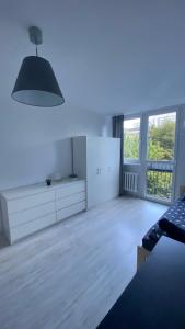 a bedroom with white furniture and a large window at Rooms in Warsaw - G9 in Warsaw