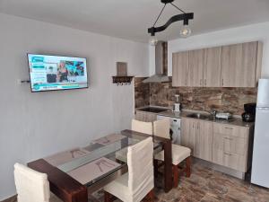 a kitchen with a dining table and a television on the wall at Luz del Mar in Orzola