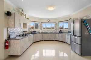 a large kitchen with stainless steel appliances and windows at NEW 3BR 2BA Private Villa with Spacious Garden in Noord