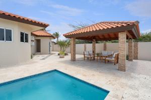 a patio with a pergola and a swimming pool at NEW 3BR 2BA Private Villa with Spacious Garden in Noord