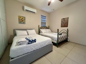 a bedroom with two beds with towels on them at Ocean View House in Quebradillas with Rooftop 