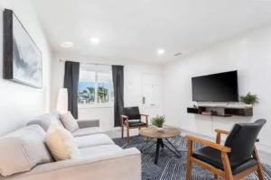a living room with a white couch and a tv at Wakefield Cozy Stay foosball FirePit Hammock in Los Angeles