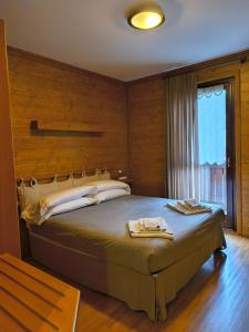 a bedroom with a large bed and a window at Hotel Sorriso in Ponte di Legno +30 photos