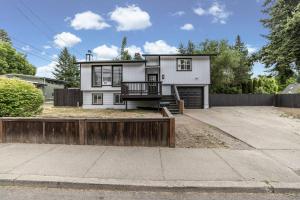 a white house with a wooden fence in front of it at CDA Family Fun Hot Tub, Game Room And More in Coeur d'Alene