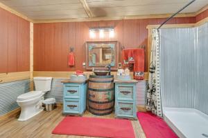 a bathroom with a tub and a toilet and a mirror at Lakeside Retreat And Game Haven in Eufaula +16 photos