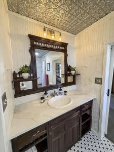 ein Badezimmer mit Waschbecken und Spiegel in der Unterkunft The 1950s Retro Riverside Cottage in Dardanelle